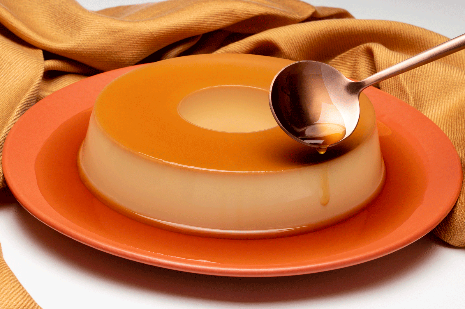 pudim de leite condensado, pano caramelo, colher derramando a calda