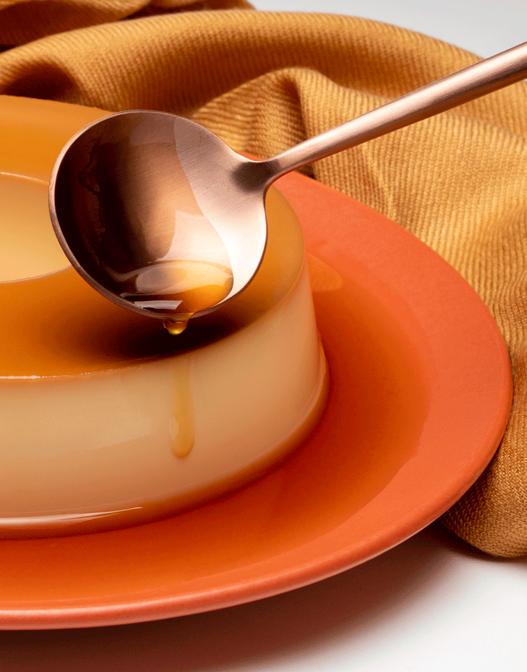 colher derramando calda no pudim de leite condensado