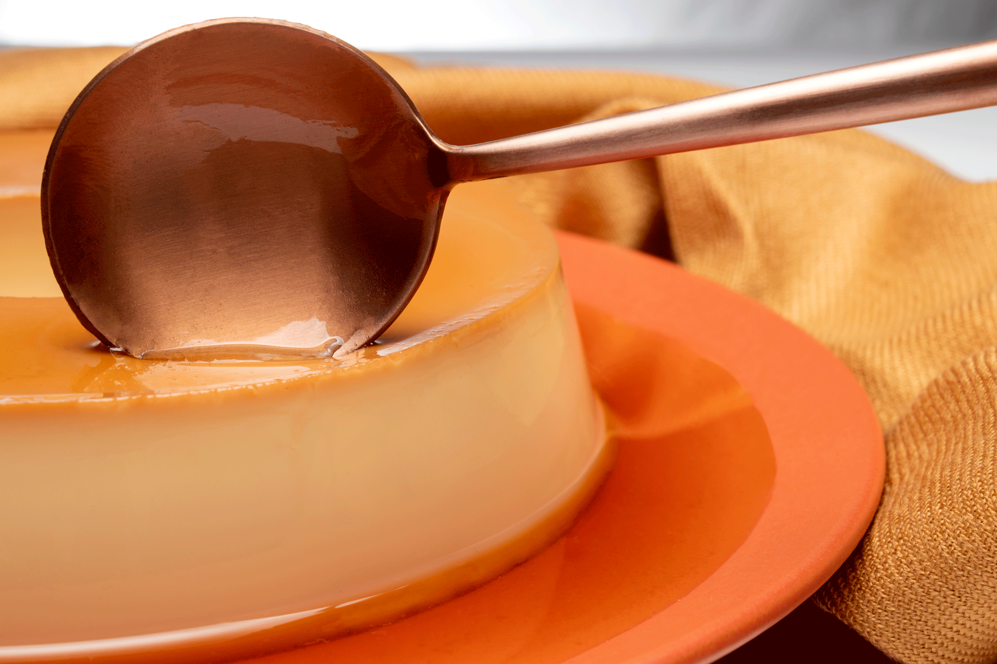 colher tocando no pudim de leite